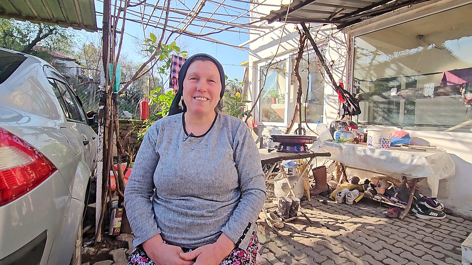 Host smiling warmly in the farmyard at Gülay & Ayşe's village house