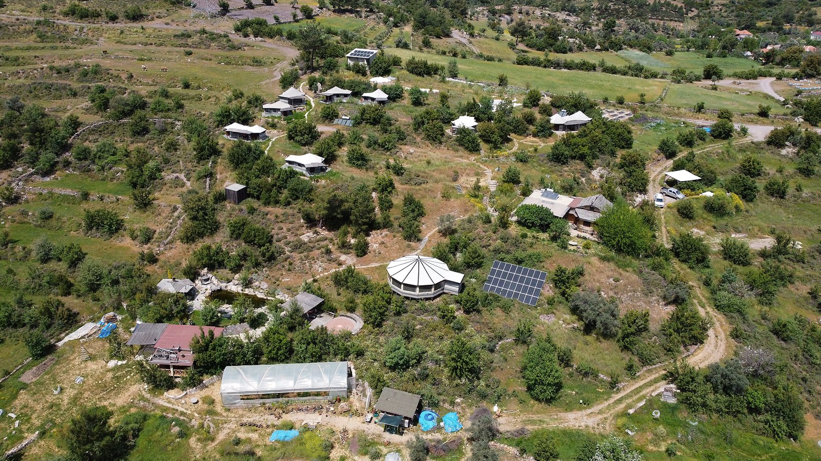 Aerial view of Valley of Breath retreat, tent cabins and natural pool nestled in the valley